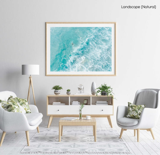 Light blue surfer paddling through foam from above in a natural fine art frame