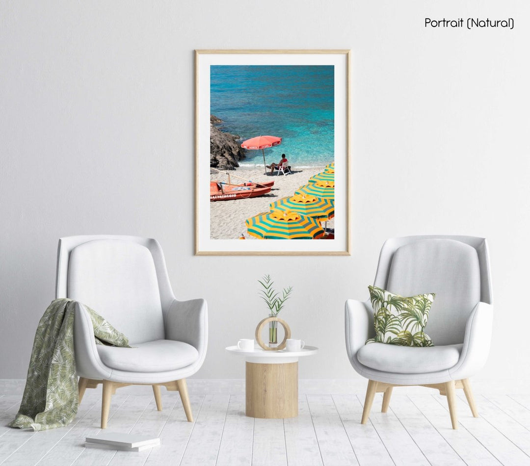 Italian lifeguard sitting under umbrella with boat at blue water on Monterosso Beach in a natural fine art frame