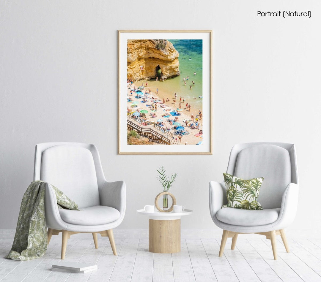 Stairway leading down to people, umbrellas, sand and green water on Camilo beach in a natural fine art frame