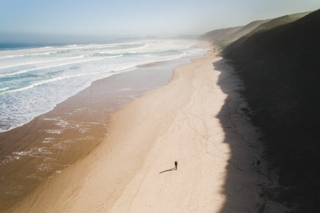 Aerial of person walking on brenton beach near Knysna