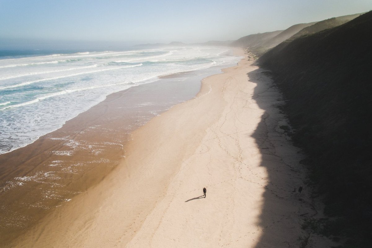 Aerial of person walking on brenton beach near Knysna