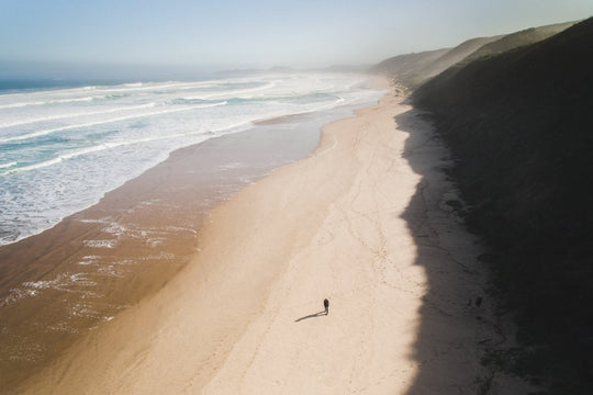 Aerial of person walking on brenton beach near Knysna