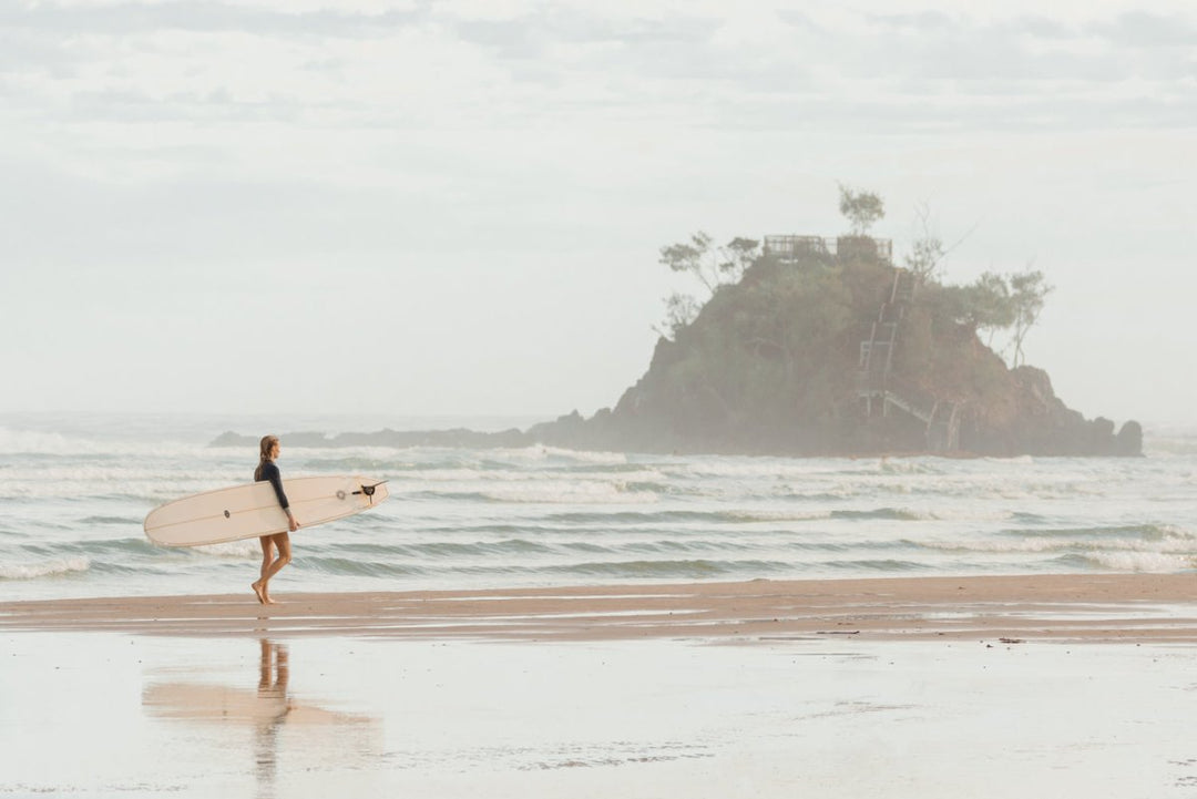 Girl walking with longboard in byron bay