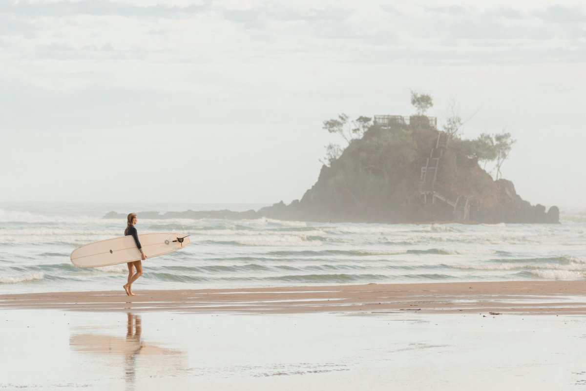 Girl walking with longboard in byron bay