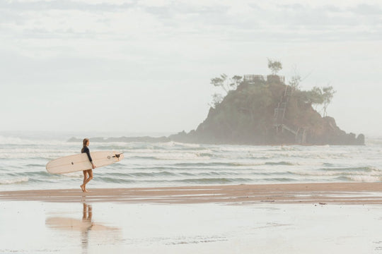 Girl walking with longboard in byron bay