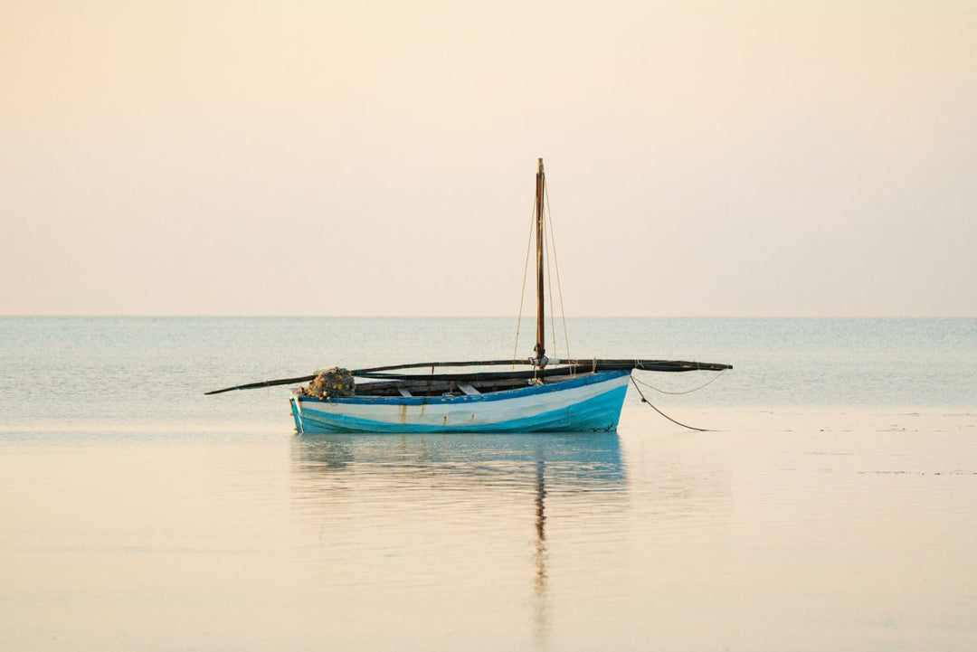 Dhow boat anchored on glassy ocean in Bazaruto Archipelago, Mozambique