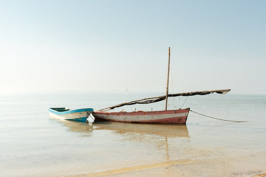 Red and blue boats tied together ashore in Bazaruto Archipelago, Mozambique