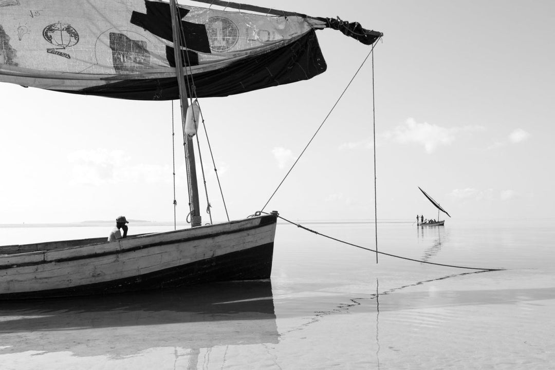 Black and white image of local fishermen in dhow boats in Bazaruto Archipelago, Mozambique