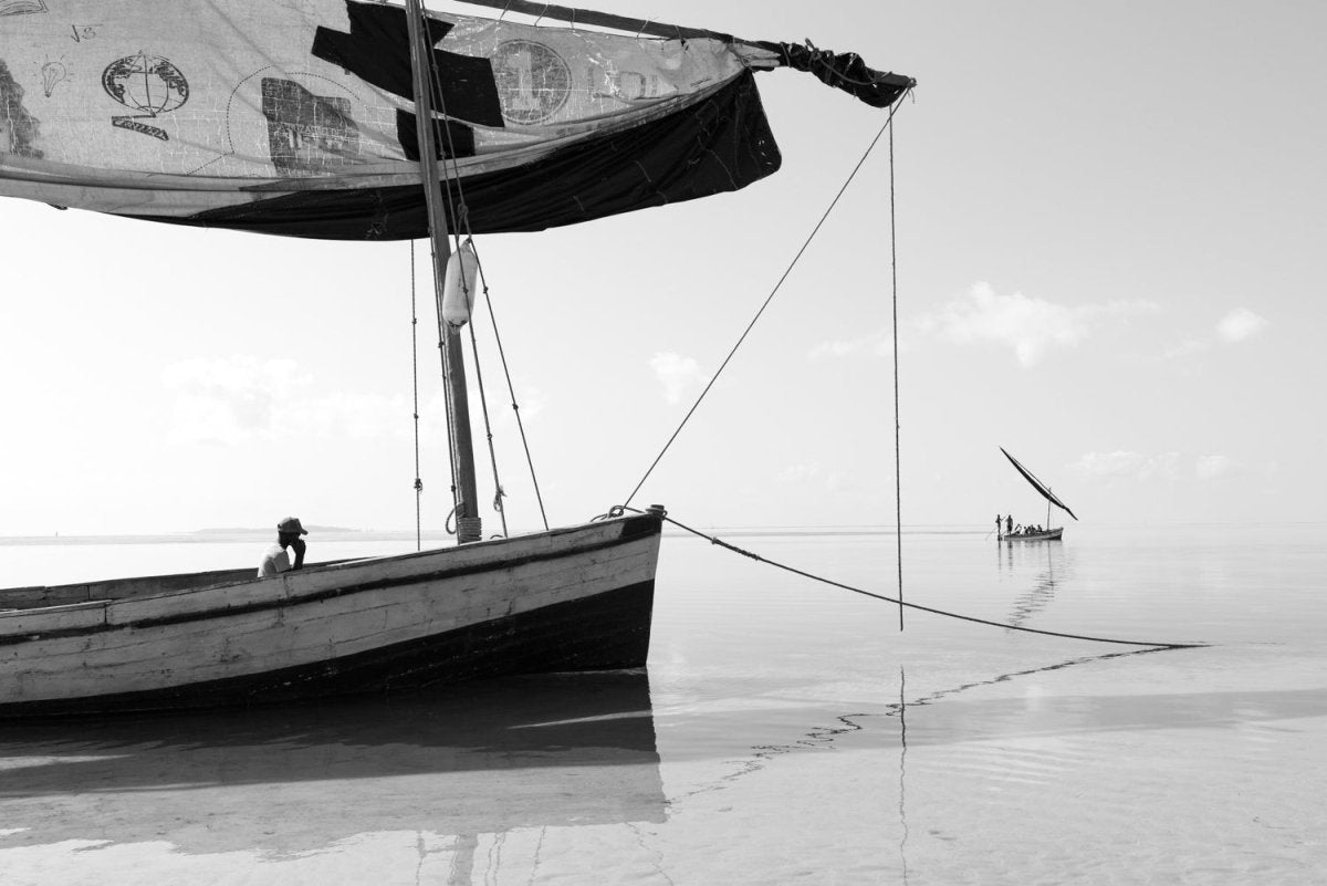 Black and white image of local fishermen in dhow boats in Bazaruto Archipelago, Mozambique