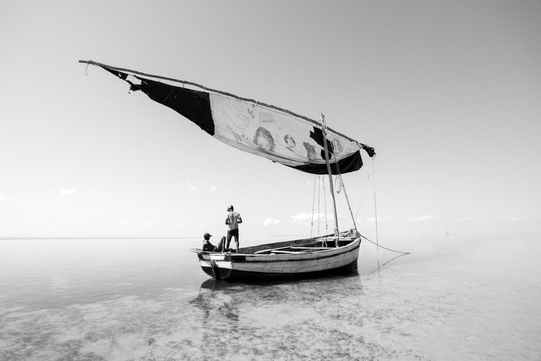 Black and white image of kids sitting in dhow boat in Bazaruto Archipelago, Mozambique