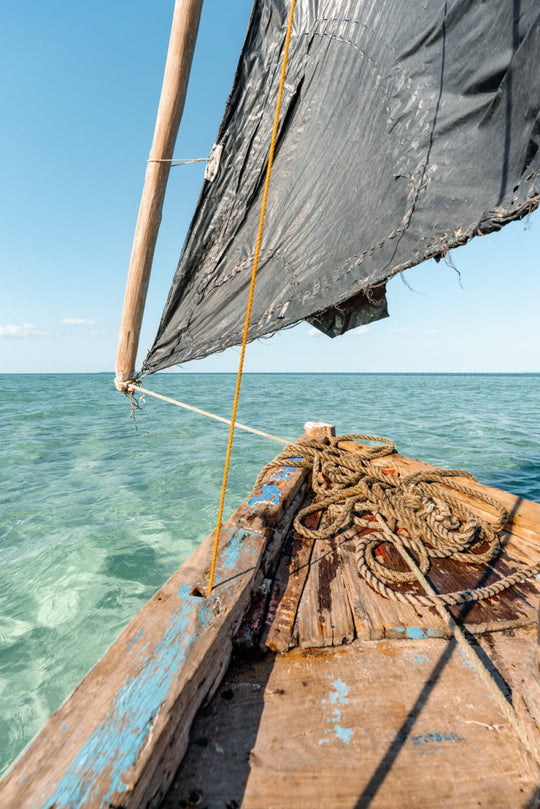 Clear blue ocean water and a wooden sailing dhow boat in Bazaruto Archipelago, Vilankulos, Mozambique