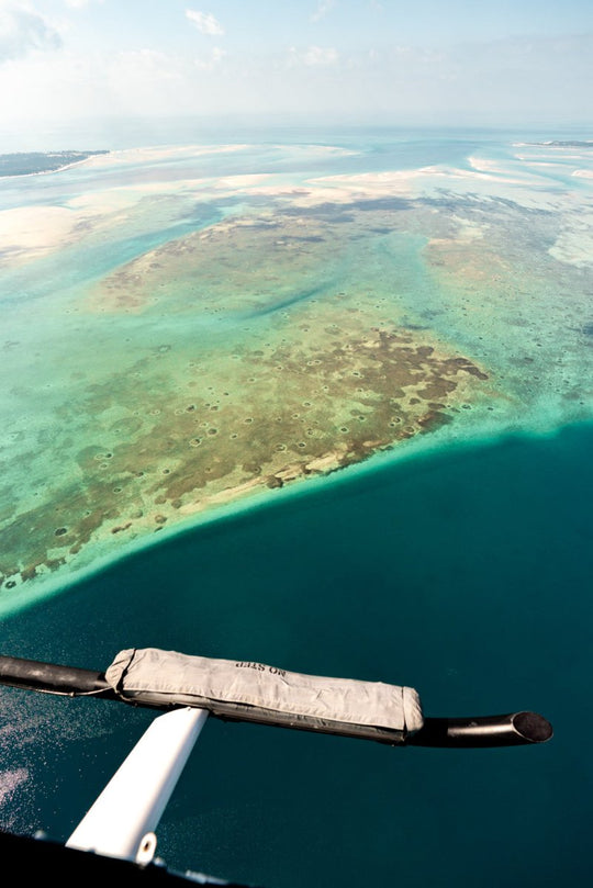 Aerial image taken from helicopter looking down at the clear ocean filled with reefs and colors in Bazaruto Archipelago, Vilankulos, Mozambique