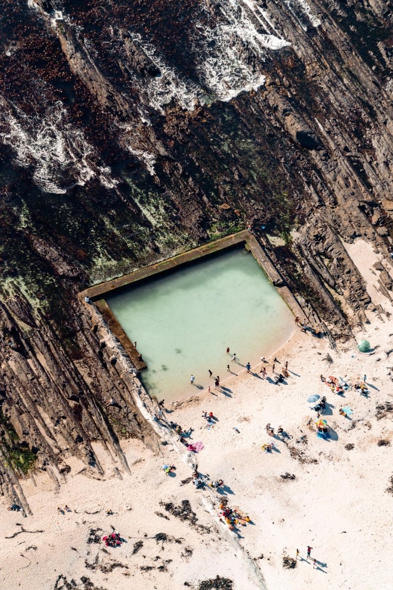 Aerial image of swimmers at a rockpool in sea point along the Atlantic Seaboard in Cape Town, South Africa.