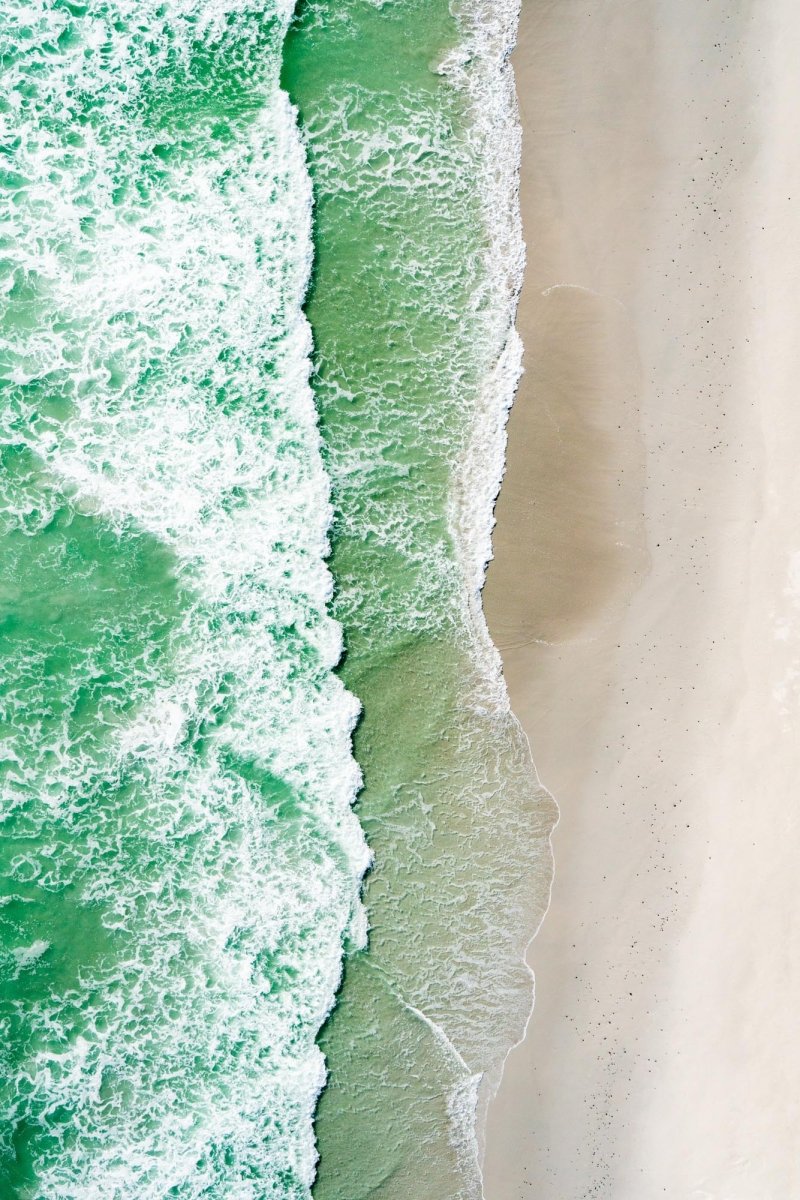 Aerial image of waves crashing on to the shore of west coast beach in Cape Town, South Africa.