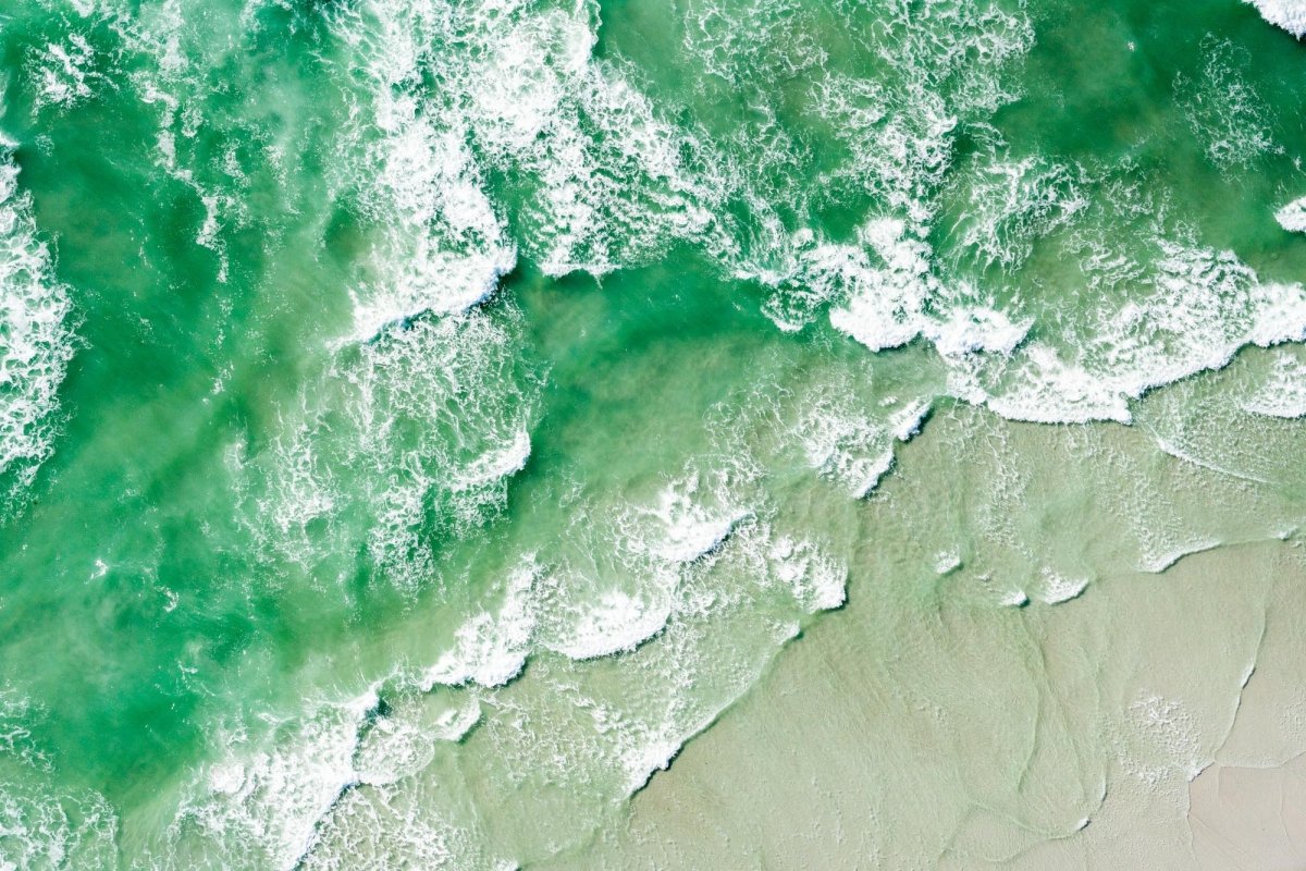 Aerial image taken from helicopter of waves crashing on beach along West Coast in Cape Town, South Africa.