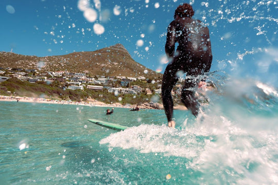 Image of a surfer longboarding at Llandudno Beach, Cape Town, South Africa.