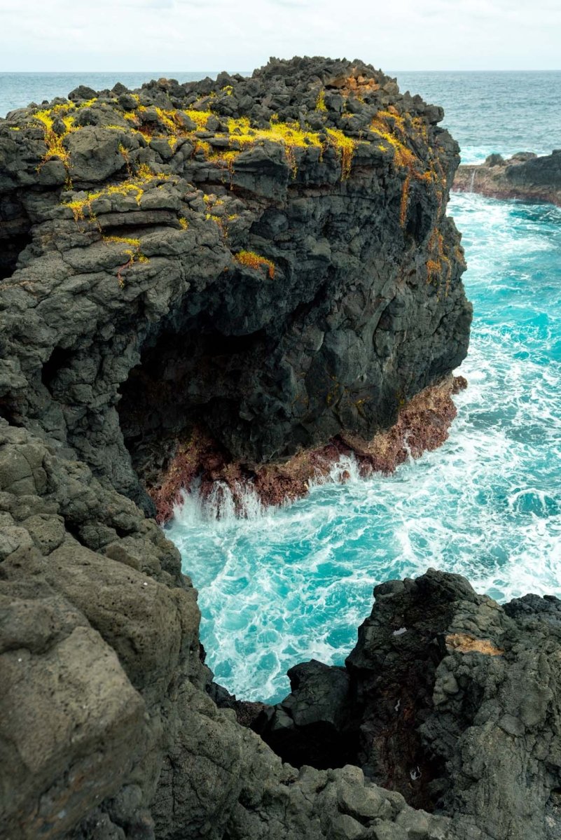 Volcanic rock meets the seas of Rolas Island.