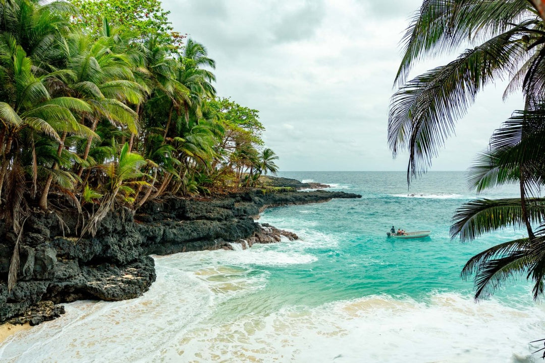 A boat in the ocean visiting Battery Beach on Rolas Island in Sao Tome.