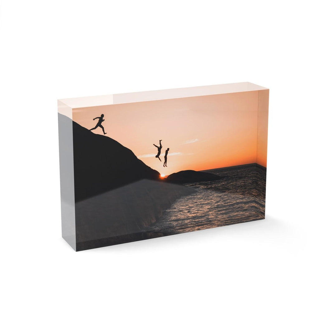 Three guys cliff jumping at sunset into ocean at Llandudno Beach