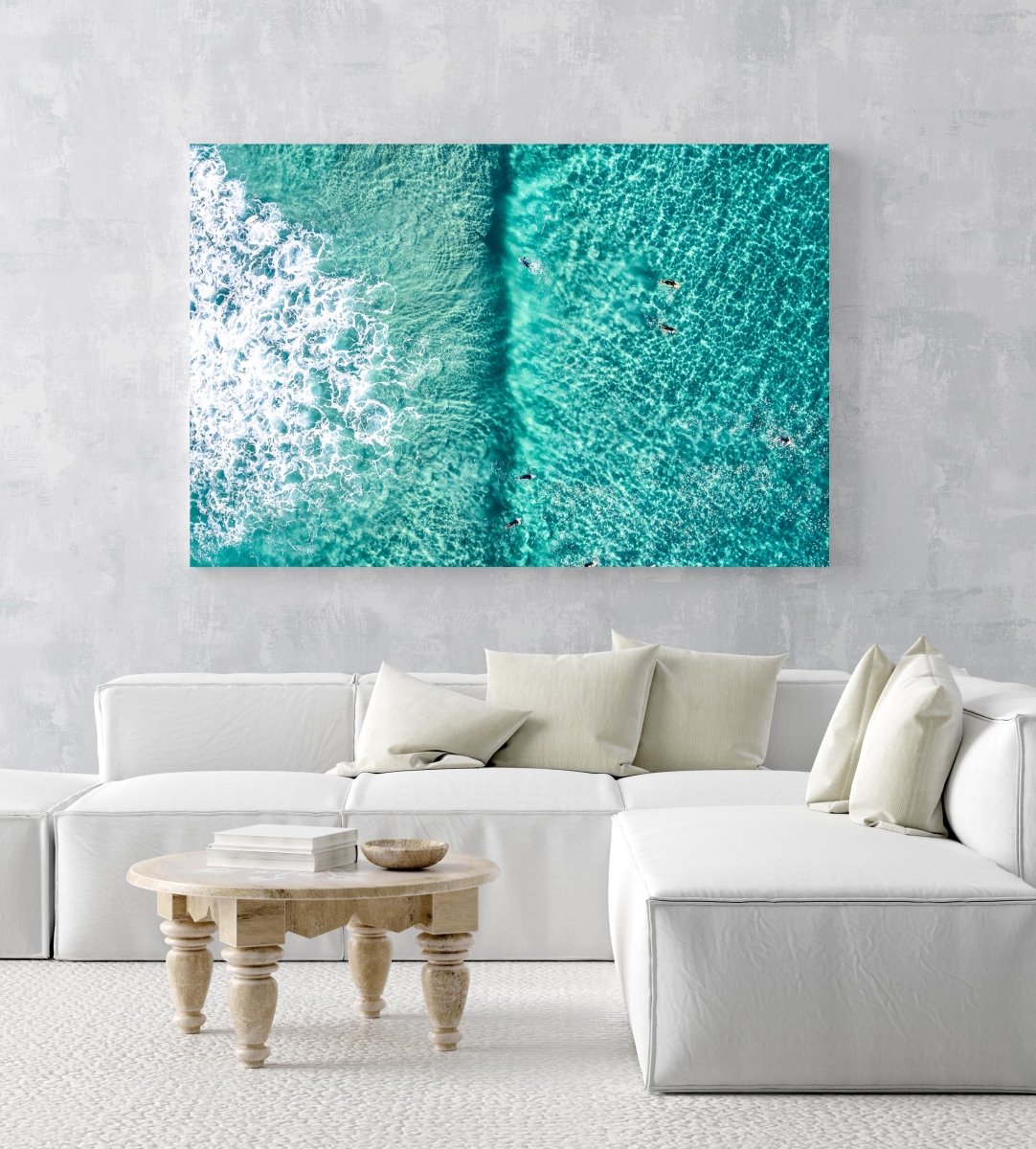 Aerial of Surfers in a turqoise ocean in an acrylic/perspex frame