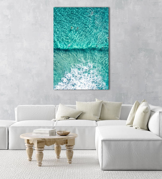 Aerial of Surfers in a turqoise ocean in an acrylic/perspex frame