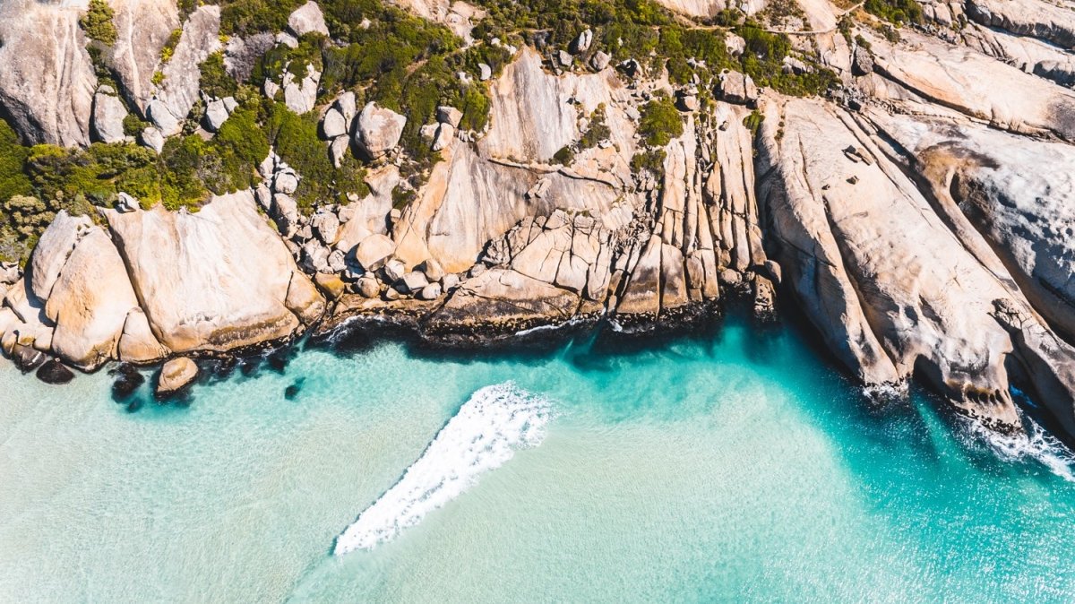 Aerial small wave breaking along Llandudno Beach in Cape Town