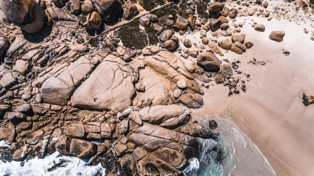 Aerial small wave breaking along Llandudno Beach in Cape Town