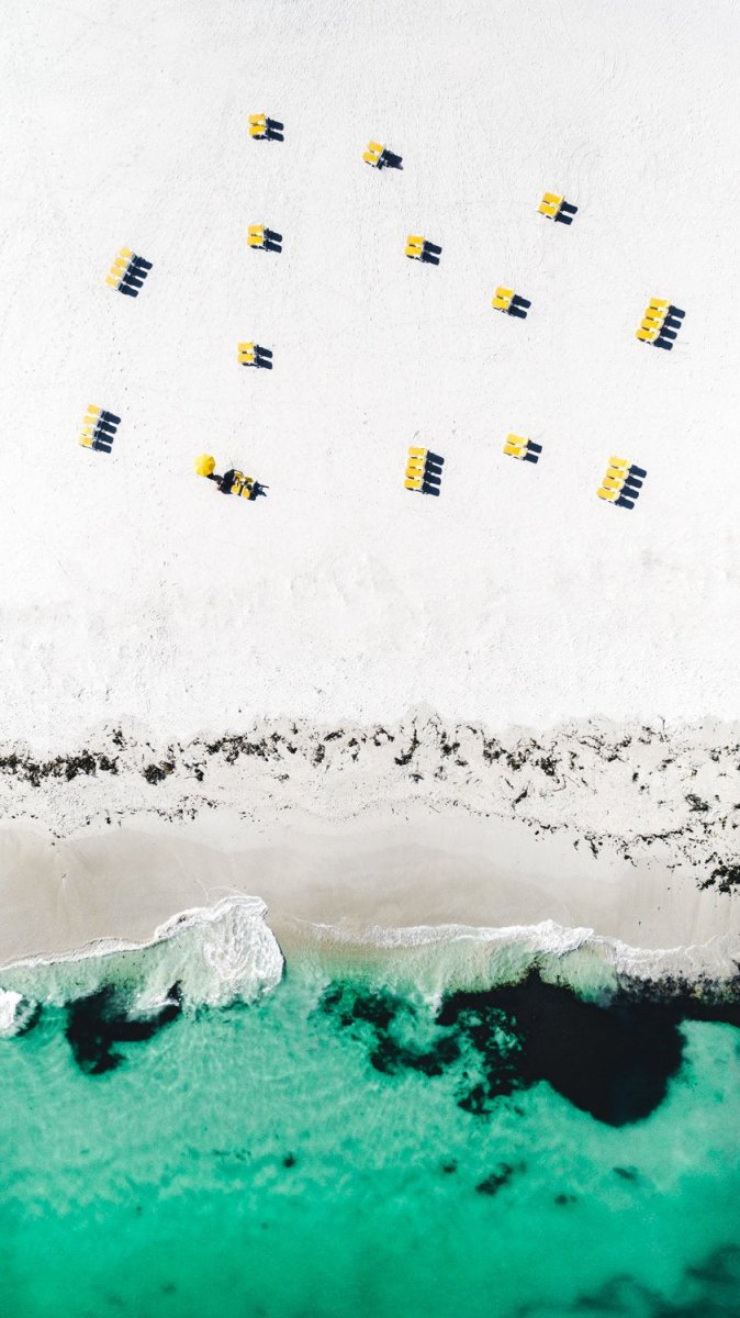 Aerial yellow beach chairs on Campsbay beach in Cape Town