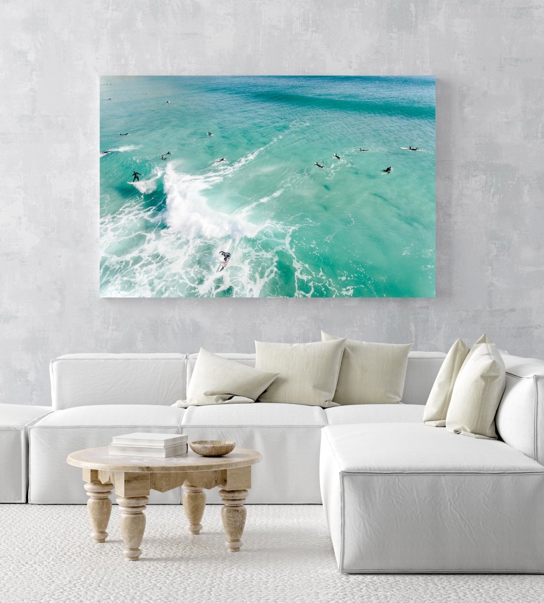 Aerial two surfers on one wave with other surfers paddling around blue swell in Cape Town in an acrylic/perspex frame