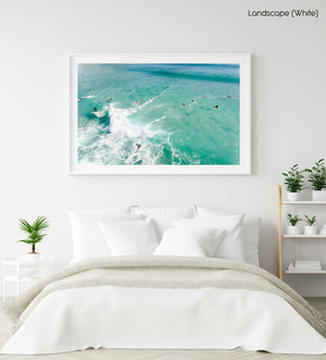 Aerial two surfers on one wave with other surfers paddling around blue swell in Cape Town in a white fine art frame