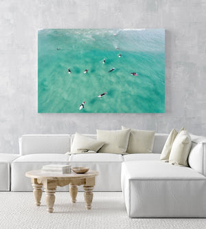 Aerial of surfers waiting and paddling for waves in sea in an acrylic/perspex frame