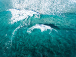 Aerial of two waves breaking in blue ocean in Cape Town