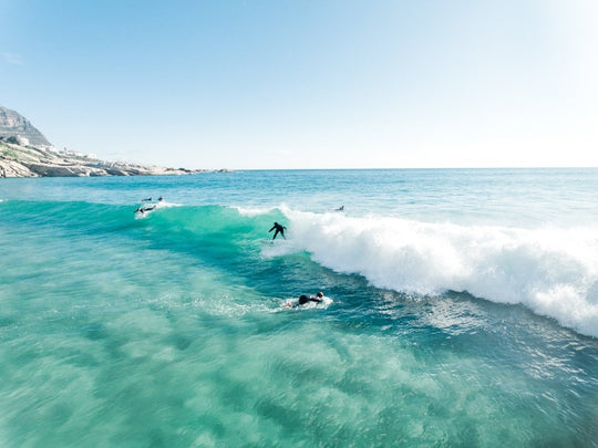 Aerial surfer going right on a small blue wave