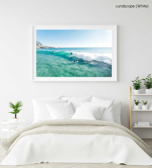 Aerial surfer going right on a small blue wave in a white fine art frame