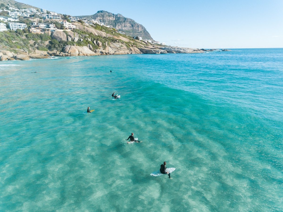 Aerial of surfers waiting on surfboards for a wave at Llandudno Beach