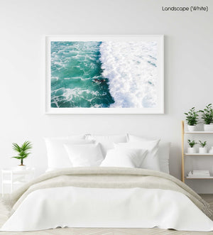 Aerial of one surfer paddling in on a foamy to Llandudno Beach in a white fine art frame