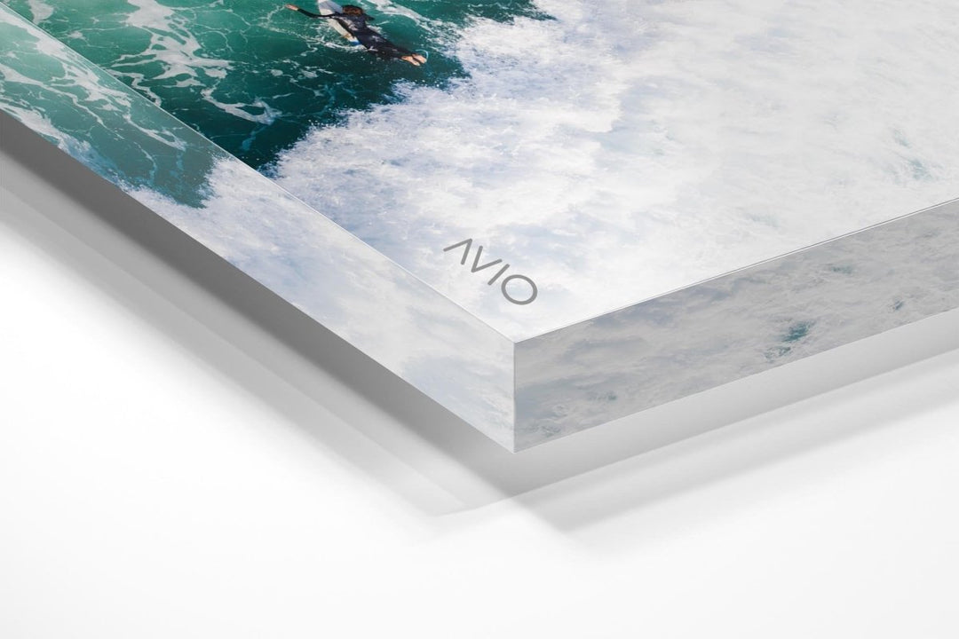 Aerial of one surfer paddling in on a foamy to Llandudno Beach in an acrylic/perspex frame