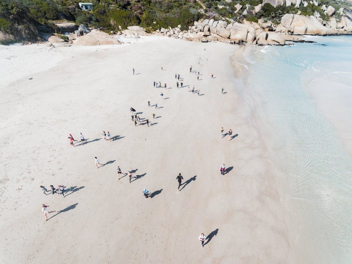 Aerial lifesavers running during training on Llandudno Beach in Cape Town