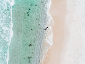 Aerial topdown of surfer walking out of water in Cape Town