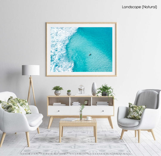 Aerial of surfer paddling in bright blue water in Cape Town in a natural fine art frame