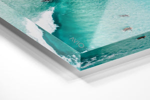 Aerial of surfers duckdiving blue wave at Glen Beach in Cape Town in an acrylic/perspex frame