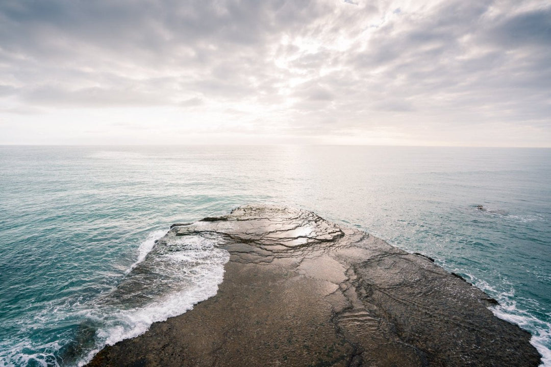 Sunset light on horizon of sea with rock in arniston