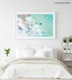 Aerial view of two surfers paddling in turquoise water and foam in a white fine art frame