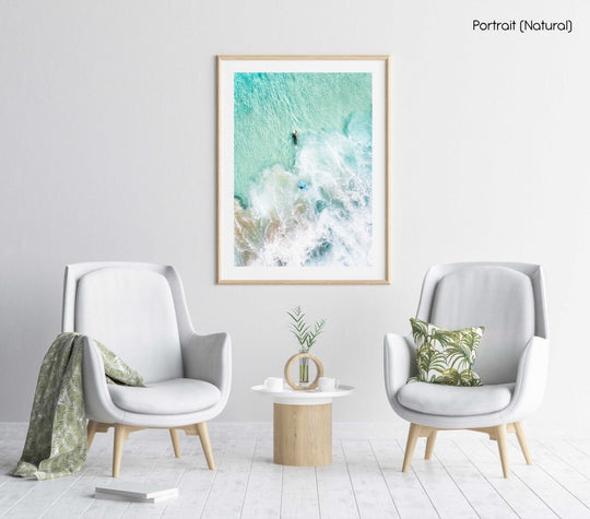 Aerial view of two surfers paddling in turquoise water and foam in a natural fine art frame