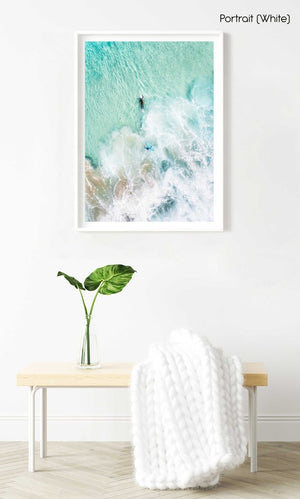 Aerial view of two surfers paddling in turquoise water and foam in a white fine art frame