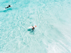 Surfers from above in light blue water in Cape Town