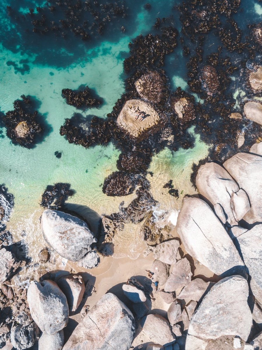 Boulders and people from above at green sea in Oudekraal Cape Town