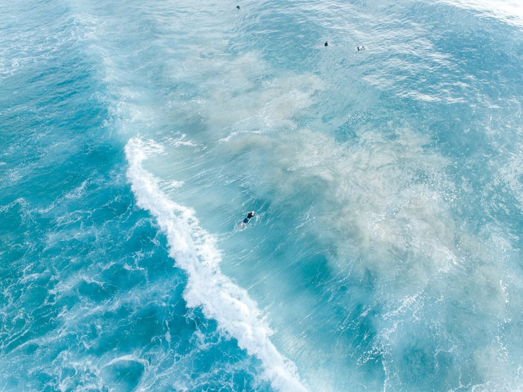 Surfers on whitewash from above in Sydney Australia