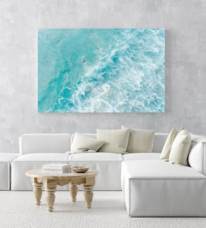Light blue surfer paddling through foam from above in an acrylic/perspex frame