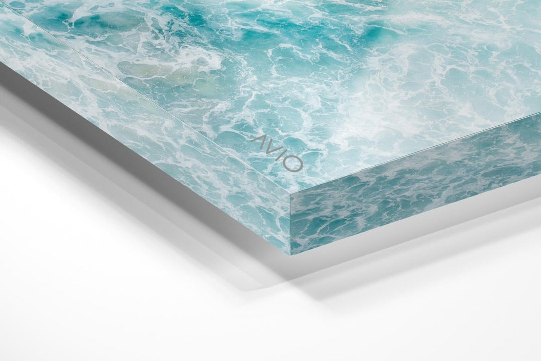 Light blue surfer paddling through foam from above in an acrylic/perspex frame